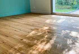 Pose d'un parquet massif dans une chambre